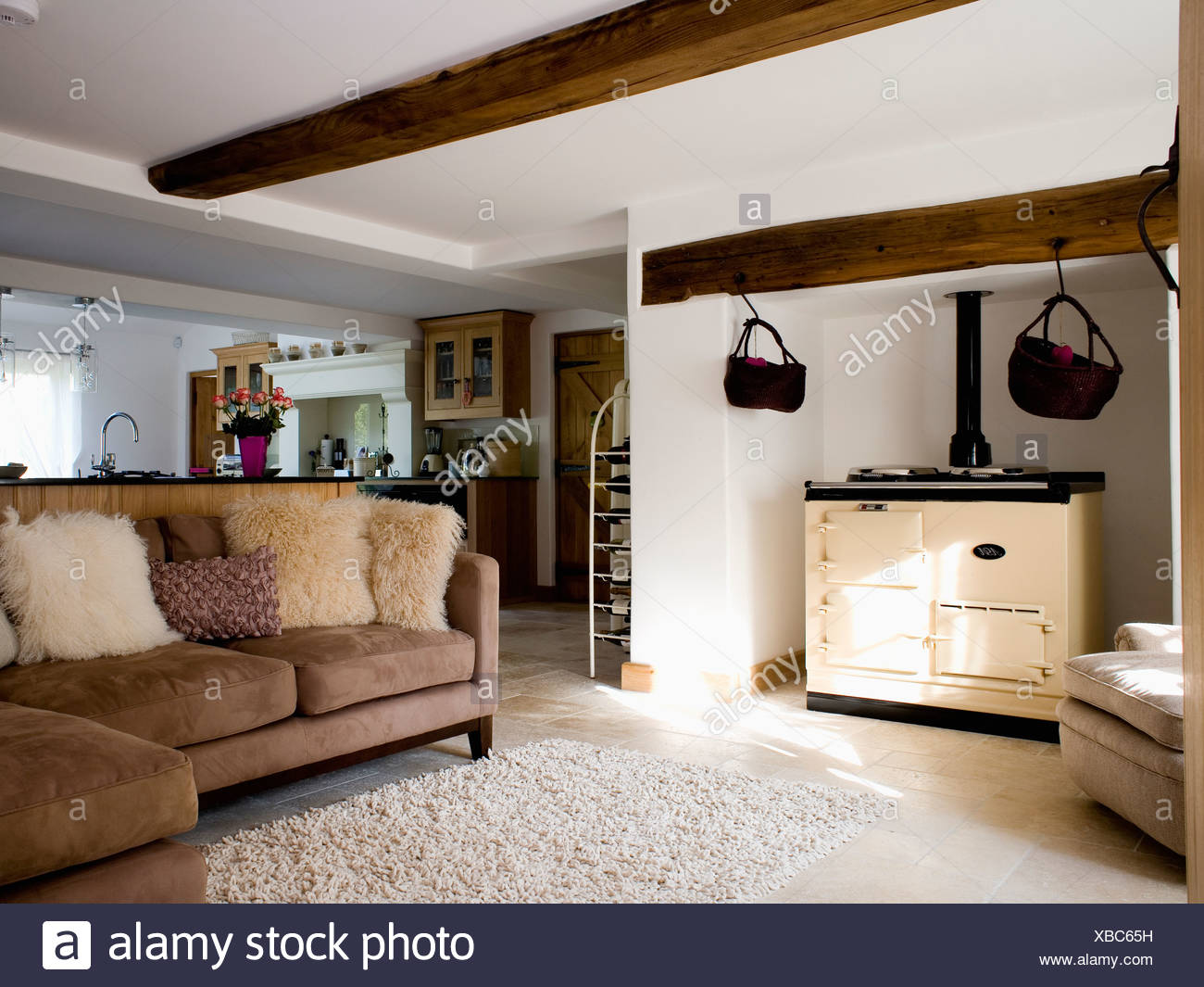 Pellicce Artificiali Cuscini In Pelle Scamosciata Marrone Divano Accanto A Crema Aga Forno In Cottage Di Campagna Cucina Con Tappeto Color Crema Su Floori Foto Stock Alamy