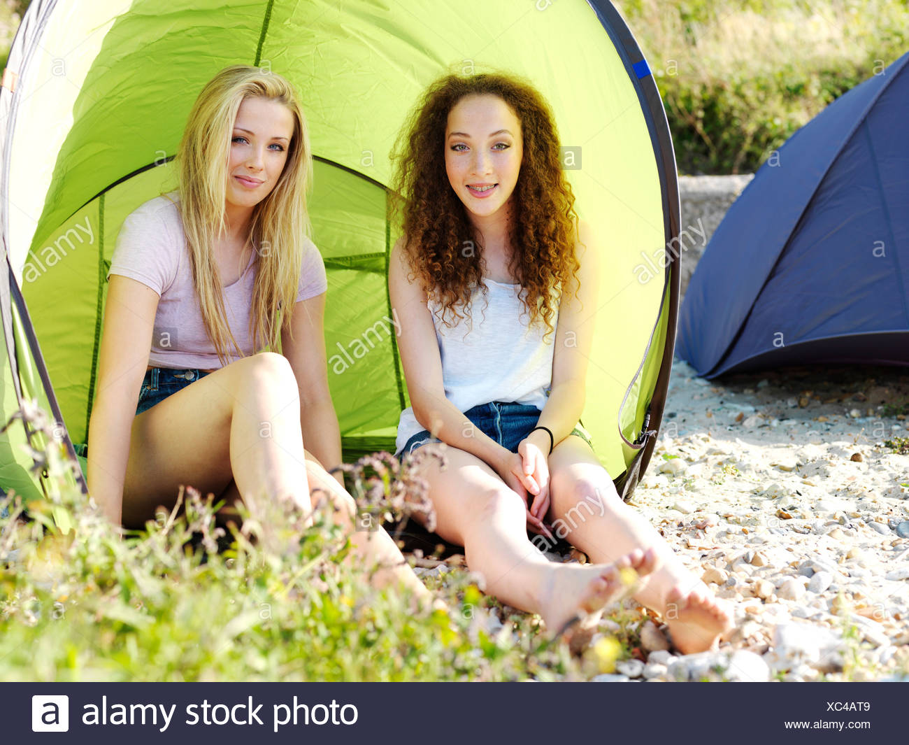 Due ragazzi tenendo selfie seduti in una tenda da campeggio Due ragazzi tenendo selfie seduti in una tenda da campeggio