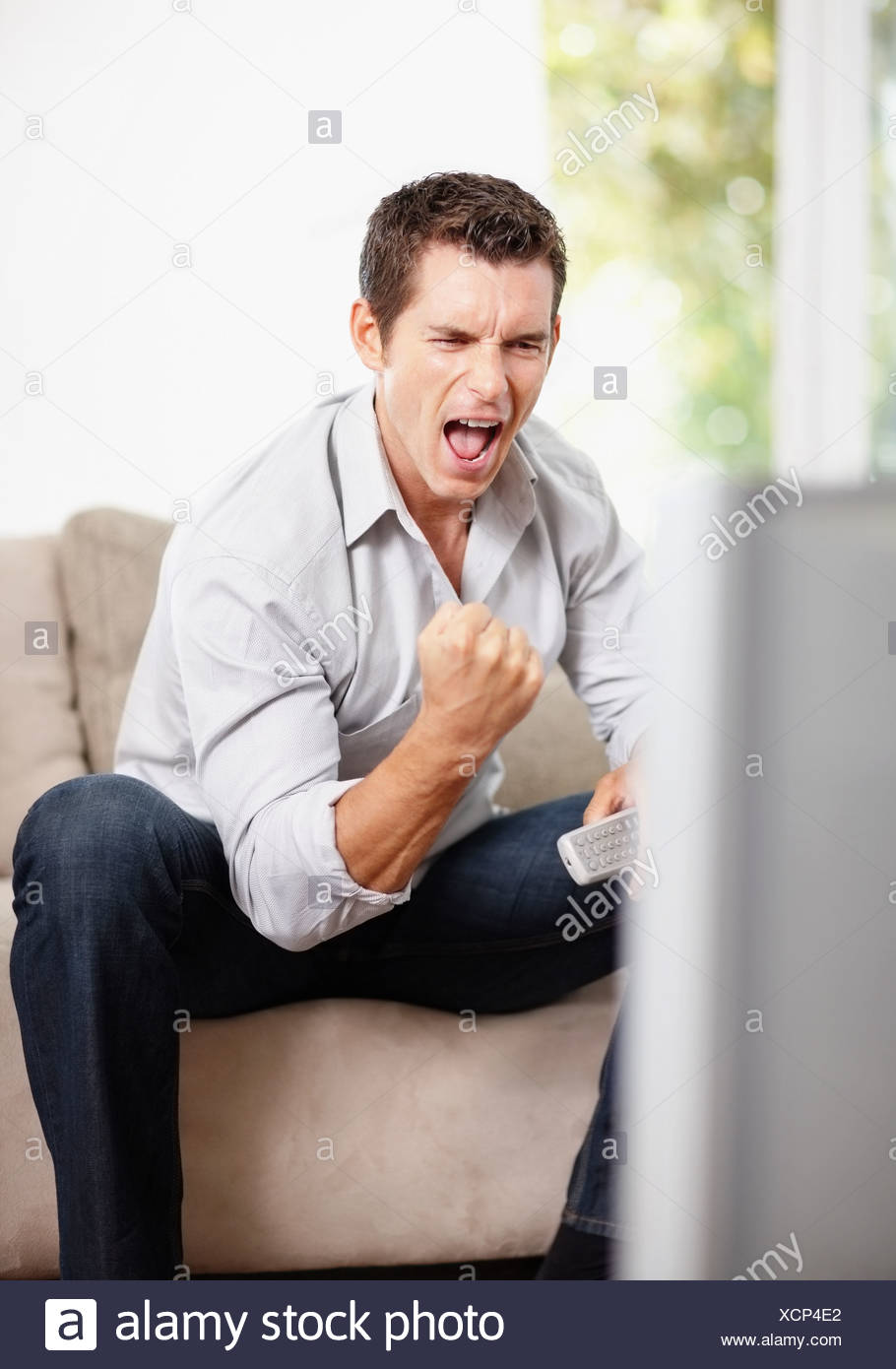 Uomo eccitato guardando la partita di calcio Foto stock - Alamy