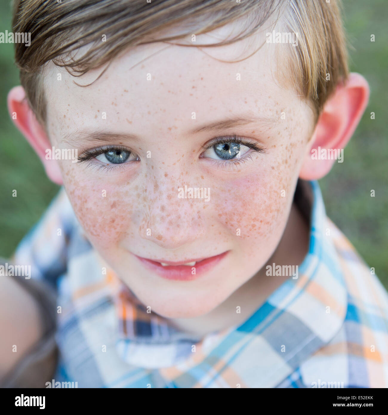 Portrait Of A Young Boy With Blue Eyes And Freckles On His Nose