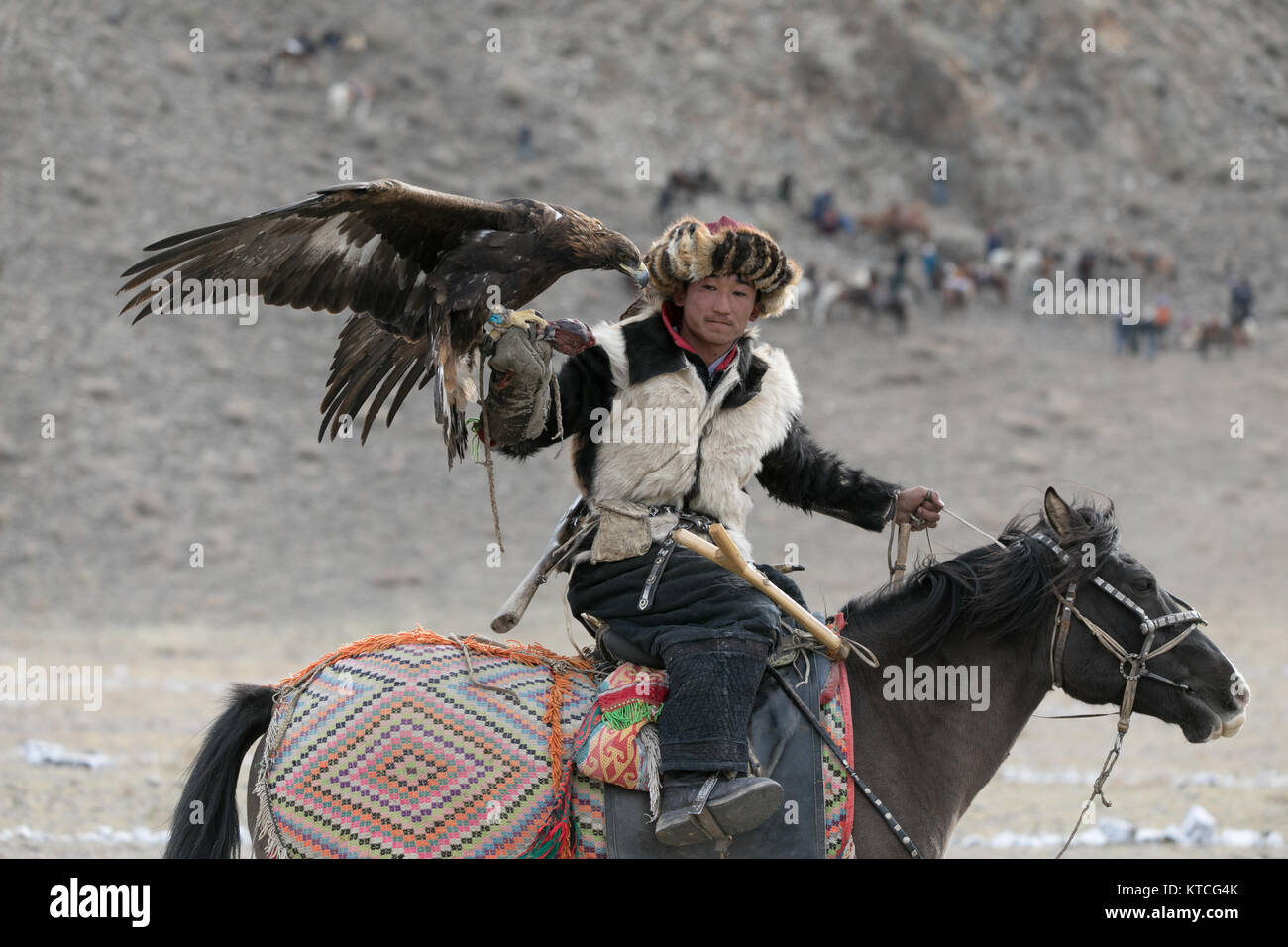 Kazakh Eagle Hunter On Horseback Competing At The Golden
