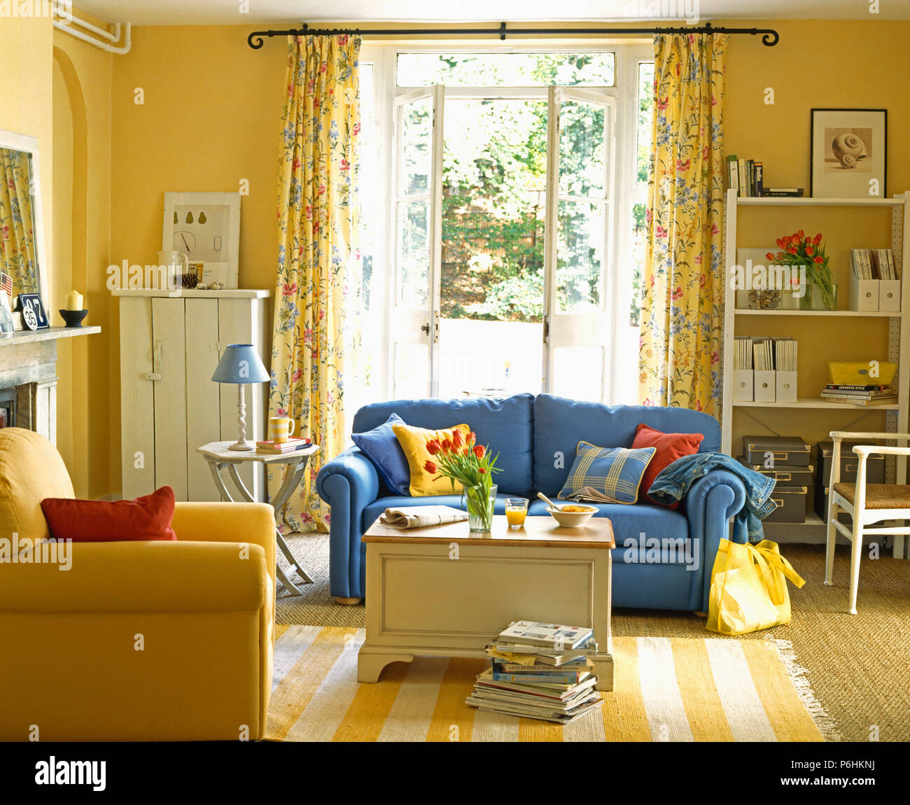 Sofá azul e amarelo tapete listrado em amarelo sala pintada com peito e